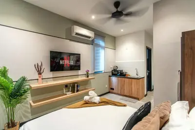 a bedroom with a bed and a tv on the wall at Neu Suites by COBNB in Kuala Lumpur