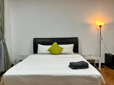 a bedroom with a large bed with a yellow pillow at Regalia Suites KL Infinity Pool _ by MygeHomes in Kuala Lumpur