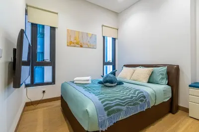a bedroom with a bed with a cat sitting on it at Lucentia Residence BBCC By Bedstay in Kuala Lumpur