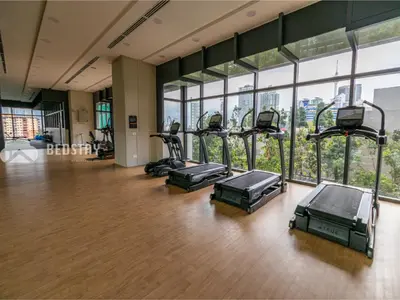 a row of treadmills in a gym with windows at Lucentia Residence BBCC By Bedstay in Kuala Lumpur