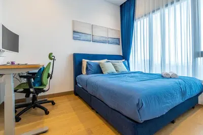 a bedroom with a blue bed and a desk and a computer at Lucentia Residence BBCC By Bedstay in Kuala Lumpur