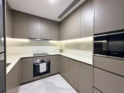 a kitchen with brown cabinets and a black appliance at Eaton Residences KLCC in Kuala Lumpur