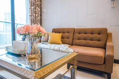 a living room with a couch and a table with flowers at Dorsett Residence Kuala Lumpur 14 in Kuala Lumpur