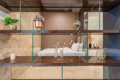 a glass shelf with a bed in a room at Dorsett Residence Kuala Lumpur 12 in Kuala Lumpur