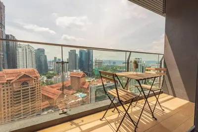 a balcony with a table and chairs on top of a building at Dorsett residence Kuala Lumpur 19 in Kuala Lumpur