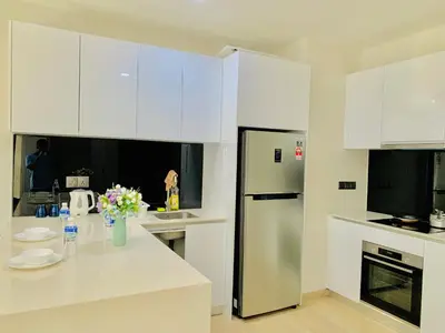 a kitchen with white cabinets and a stainless steel refrigerator at Star KLCC by Arman in Kuala Lumpur