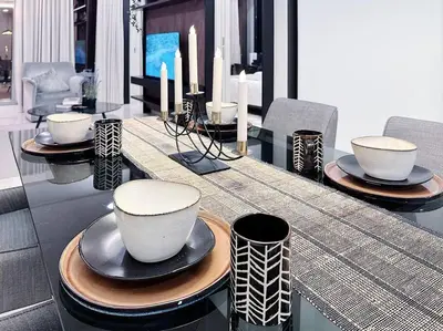 a dining room with a table with bowls and candles at Tropicana The Residence Onebedroom suite by VVHOMESTAY in Kuala Lumpur