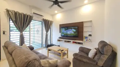 a living room with a couch and a tv at A Place Like Home Landed House Kuala Lumpur in Kuala Lumpur