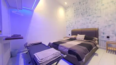 a bedroom with a bed in a blue room at A Place Like Home Landed House Kuala Lumpur in Kuala Lumpur