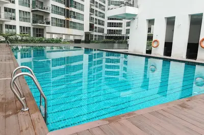 a large blue swimming pool in front of a building at MyRehat Regalia Residences in Kuala Lumpur