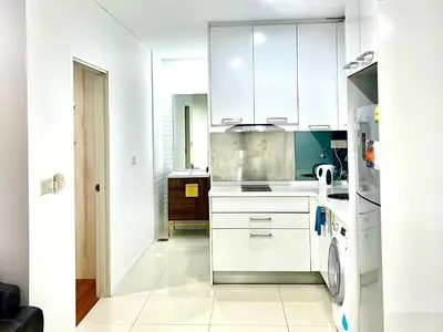 a kitchen with white cabinets and a washer and dryer at Summer Suites KLCC By Whollmark in Kuala Lumpur