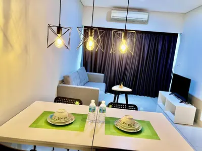 a living room with a table and a couch at Summer Suites KLCC By Whollmark in Kuala Lumpur