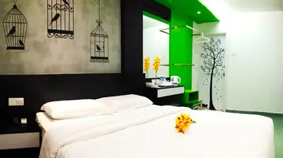 a bedroom with a white bed and a green wall at Tai Ichi Hotel Kuala Lumpur in Kuala Lumpur