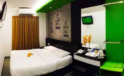 a hotel room with a bed and a green ceiling at Tai Ichi Hotel Kuala Lumpur in Kuala Lumpur