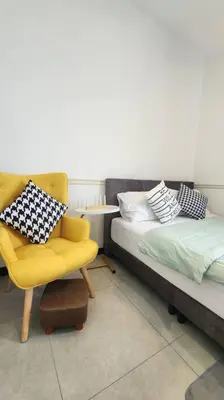 a bedroom with a yellow chair and a bed at The Nova by The City Collection in Kuala Lumpur