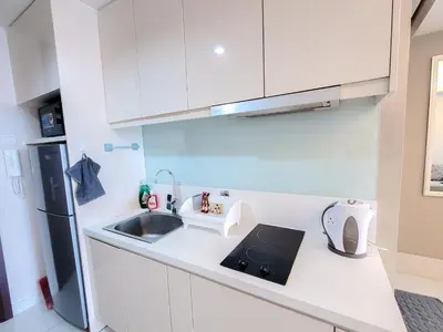 a white kitchen with a sink and a refrigerator at Damas Residence Kuala Lumpur in Kuala Lumpur