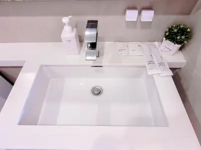 a white sink in a white bathroom with aacted at Damas Residence Kuala Lumpur in Kuala Lumpur