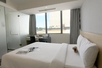 a hotel room with a white bed with a window at Pacific Express Hotel Central Market Kuala Lumpur in Kuala Lumpur