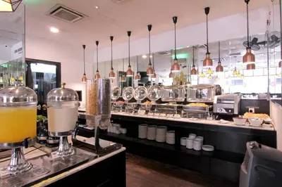 a restaurant kitchen with a counter with a bar at Pacific Express Hotel Central Market Kuala Lumpur in Kuala Lumpur