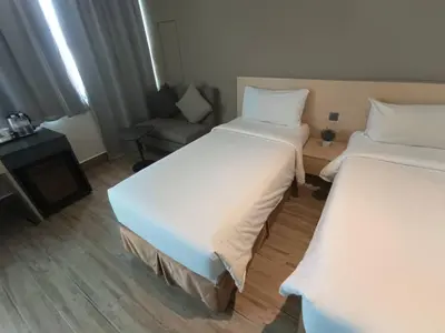a hotel room with two beds and a couch at Pacific Express Hotel Central Market Kuala Lumpur in Kuala Lumpur