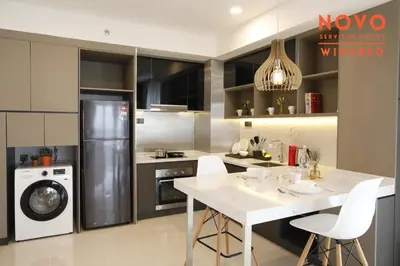a kitchen with a white table and a refrigerator at NOVO Serviced Suites by Widebed, Jalan Ampang, Gleneagles in Kuala Lumpur