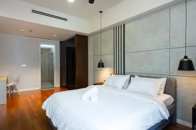 a bedroom with a large white bed with two pillows at MyRehat Anggun Residences in Kuala Lumpur