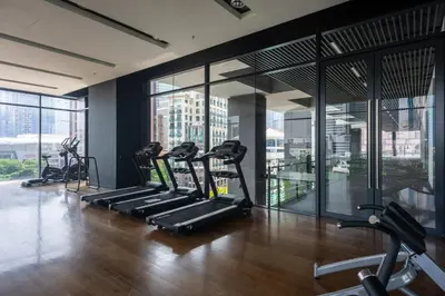 a gym with several tread machines in a room with windows at MyRehat Anggun Residences in Kuala Lumpur