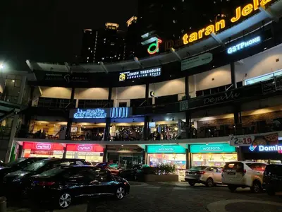 a parking lot with cars parked in front of a building at Superb Maya Twin Tower View in Kuala Lumpur