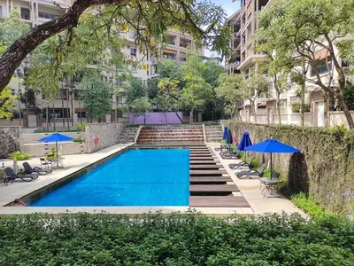 a swimming pool with chairs and umbrellas next to a building at Superb Maya Twin Tower View in Kuala Lumpur