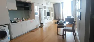 a kitchen and a living room with a table and a tableablish at Sidemen Suites at Platinum KLCC in Kuala Lumpur