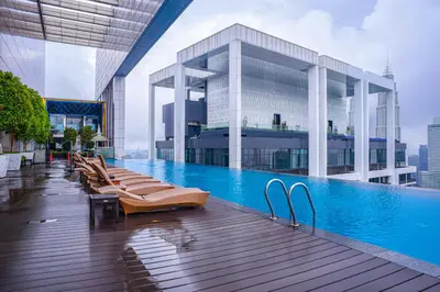 a pool on the top of a building with lounge chairs at Sidemen Suites at Platinum KLCC in Kuala Lumpur