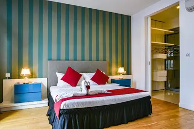 a bedroom with a large bed with red pillows at Sidemen Suites at Platinum KLCC in Kuala Lumpur