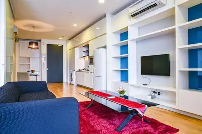 a living room with a blue couch and a tv at Sidemen Suites at Platinum KLCC in Kuala Lumpur