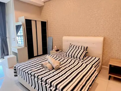 a bedroom with a large bed with striped sheets and pillows at Seputeh Cozy & Homely VIVO Suite Old Klang Road Near MidValley, The Garden Mall in Kuala Lumpur