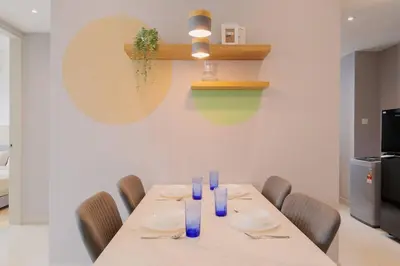 a dining room with a table with chairs and blue glasses at Datum Jelatek Balcony w Infinity Pool Linked LRT KLCCView Mall in Kuala Lumpur