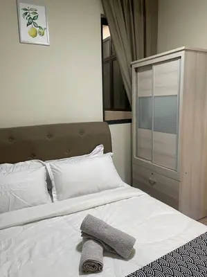 a bedroom with a white bed with a towel on it at Cozy Family Suite Kepong DesaPark MontKiara Publika Mitec in Kuala Lumpur