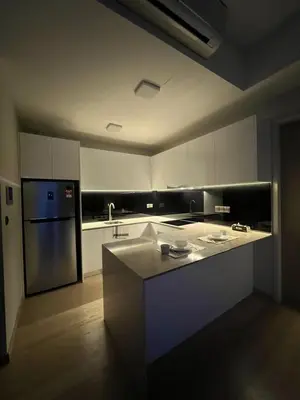 a kitchen with white cabinets and a refrigerator and a sink at Star Residence Apartment with High Kuala Lumpur view in Kuala Lumpur