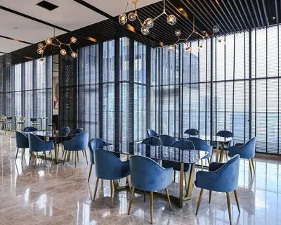 a dining room with blue chairs and tables and large windows at Star Residence Apartment with High Kuala Lumpur view in Kuala Lumpur