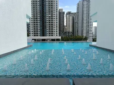 a large swimming pool with white swans in a city at Muji Style, Inspirasi Residences Mont Kiara in Kuala Lumpur