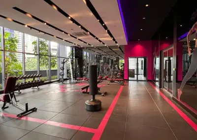a gym with benches and machines in a building at Star Residence Apartment with twin towers KLCC view in Kuala Lumpur