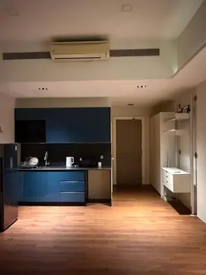 a large kitchen with blue cabinets and a wooden floor at M City Minimalist KLCC Suite in Kuala Lumpur
