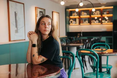 a woman sitting at a table in a restaurant at Scarletz Leisure Suites KLCC in Kuala Lumpur