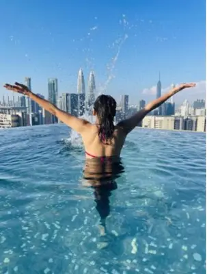 a woman standing in the water with her arms outstretched at Expressionz Leisure Suites KLCC in Kuala Lumpur