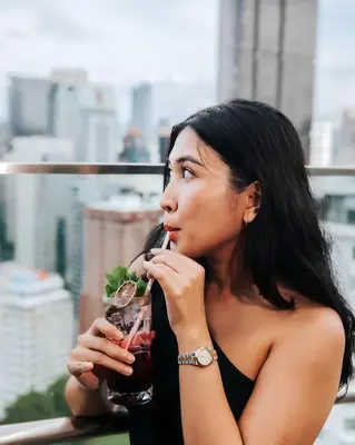 a woman in a black dress eating a drink at Ceylonz Leisure Suites KLCC Bukit Bintang in Kuala Lumpur