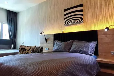a bedroom with a large bed and a painting on the wall at KLCC Luxurious 2 Floors Homestay 5BR for 15pax in Kuala Lumpur