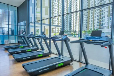 a row of treadmills in a gym with large windows at Zen 3-bedroom w pool 6 pax - Semarak in Kuala Lumpur