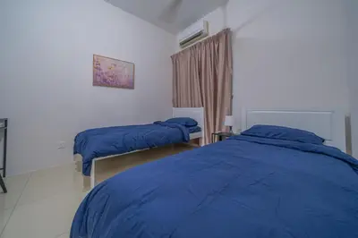 a bedroom with two beds with blue comforters at Zen 3-bedroom w pool 6 pax - Semarak in Kuala Lumpur