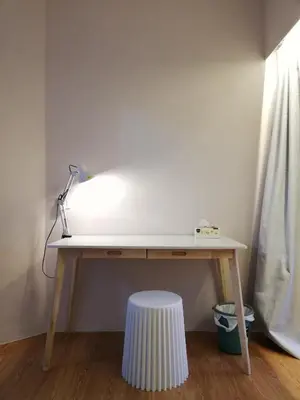 a desk with a lamp and a stool under it at Ampang Hilir Lake View in Kuala Lumpur