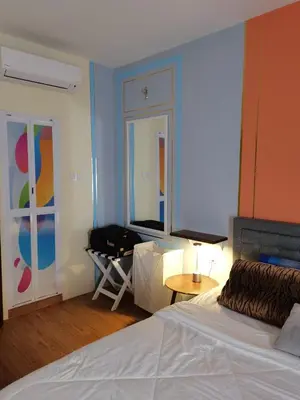 a bedroom with a bed and a table and a window at Ampang Hilir Lake View in Kuala Lumpur