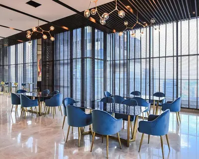 a dining room with blue chairs and tables and large windows at Star residance KLCC-Two bedroom Apartment in Kuala Lumpur